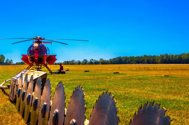 — — - Hughes 500 pilot/mechanic works on his engine. The saw blade assembly hangs from the helicopter in flight and is used to trim trees around large power lines. Picture taken in Aiken SC. a rel=nofollow href=http://www.ThePilotsEye.comwww.ThePilotsEye.com/a