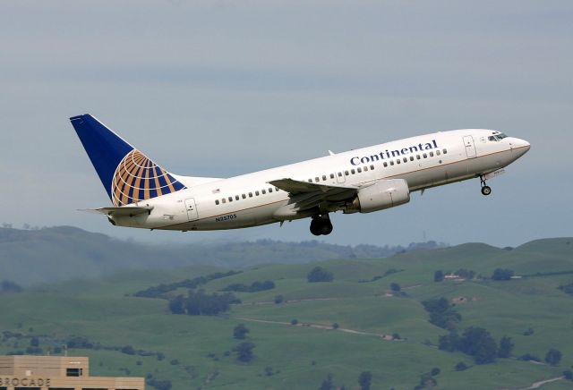 Boeing 737-700 (N25705) - KSJC - Continental 737-700 headed out for Denver - the hills in the background and roadway cutting through the grass is Sierra Rd above Piedmont Hills High School.