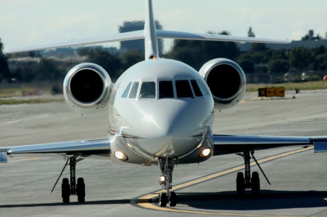 Dassault Falcon 2000 (N221QS) - Taxiing to 30L for take off. Pilots stopped in front of me, illuminating the exterior landing lights for the picture