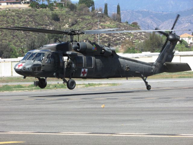 — — - Army chopper delivering patient to waiting ambulance.