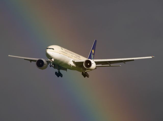 Boeing 777-200 (HZ-AKA) - Passing straight through a rainbow at the end of runway 23R.