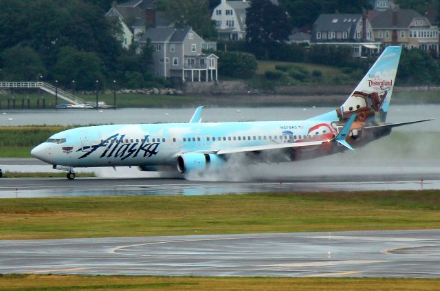 Boeing 737-800 (N570AS) - Alaska 12 from Seattle, in Disney Cars livery, landing on a rain soaked 33L