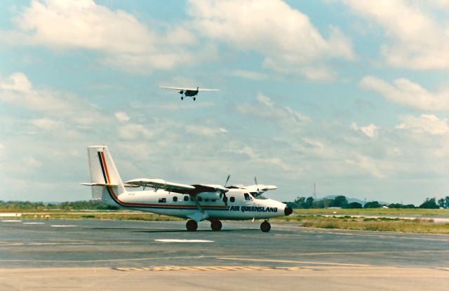 De Havilland Canada Twin Otter (VH-TGF) - Air Queensland Twin Otter on the old terminal ramp. Southern Cross Replica Mackay Qld 1987 taking off in the back ground.