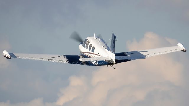 Beechcraft Bonanza (36) (N89ED) - N89ED climbing out of College Park Airport's runway 33 with some nice clouds in the background 