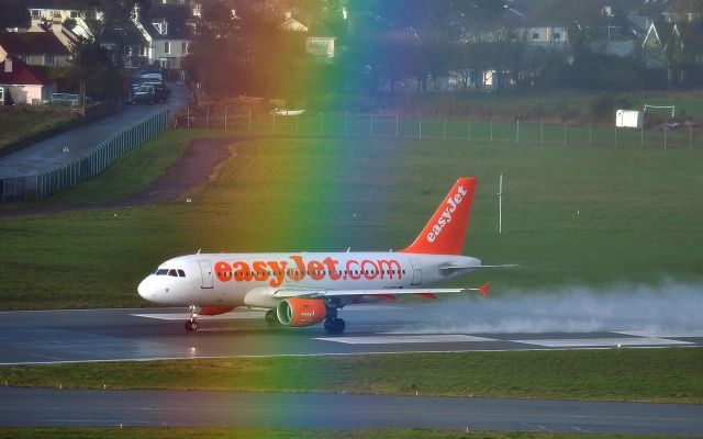 Airbus A319 (G-EZAY) - EasyJet A319 departing during a rain shower and rainbow at Jersey 3/Mar/2016
