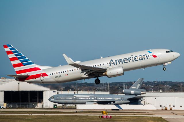 Boeing 737-800 (N982AN) - Departing 13R. In the background is a DC-10 being retrofitted for Omega AIr Refueling.