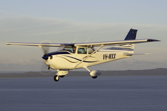 Cessna Skyhawk (VH-WXX) - Inflight photo soon after a fresh paint job and a new look. Photo taken over Bribie Island with Moreton island in the background.