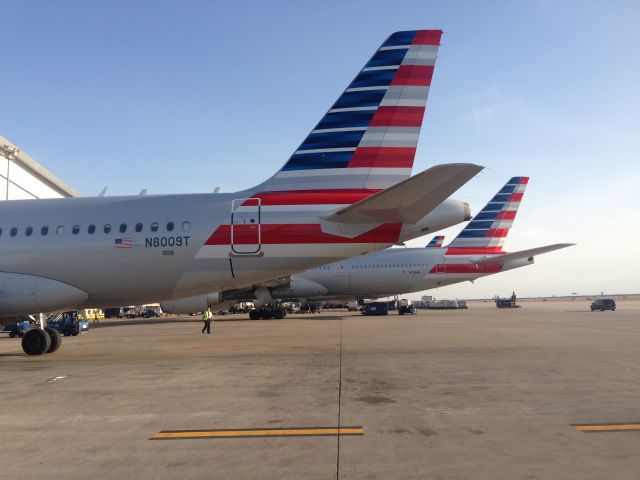 Airbus A319 (N8009T) - At the AA terminal. B777-300ER (N719AN) in background