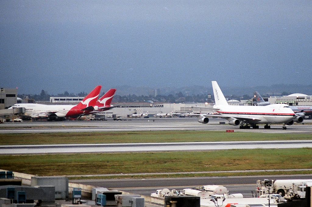 Boeing 747-200 (JA8107) - KLAX Japan cargo crossing 25R/L as a QANTAS 747SP and 747-200 load at the Intl terminal date apprx March 1988?
