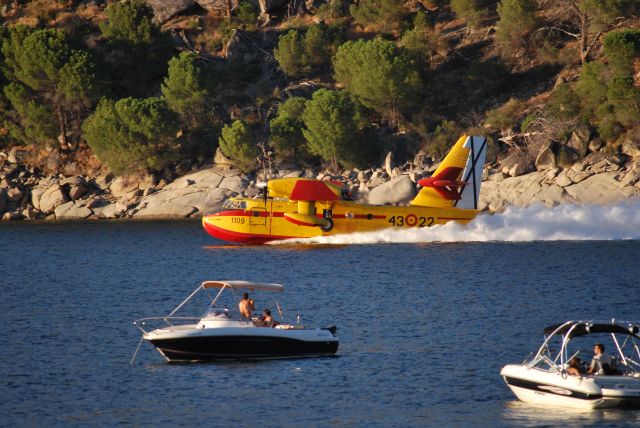 — — - Carga de un hidroavión de bomberos en pantano de San Juan (Madrid) para atajar un incendio forestal en Cebreros, Avila, España,