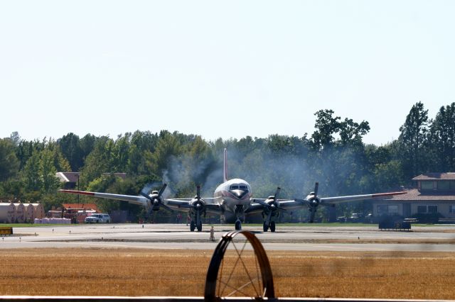 Douglas DC-7 (N838D) - KRDD - after a 10 minute load, this workhorse DC-7 rolling to the main for an immediate take off for Weed CA for the fast moving Boles Fire 2014 - I was on the ladder and didnt know the -7 would line up perfectly with the rolling sprinkler - oooooooooof! Blew my nose shot! Click full for large image!