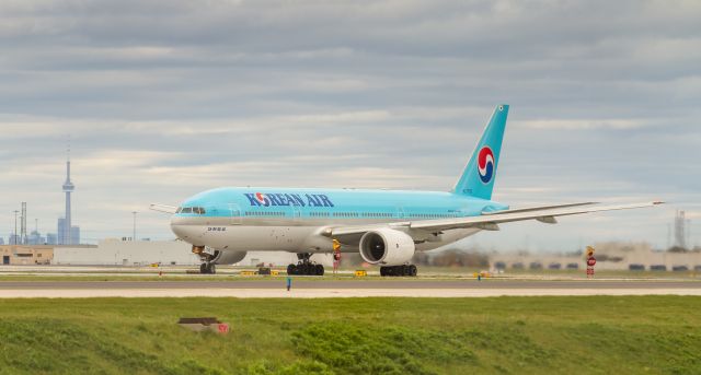 Boeing 777-200 (HL7752) - KAL74 starts her takeoff roll on runway 33R at YYZ. CN Tower in the background.