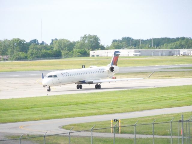 Canadair Regional Jet CRJ-900 (N932XJ) - FLG 3293 taxiing to takeoff from runway 4 at KROC.  Taken from the dirt pile near Old Beahan Road.