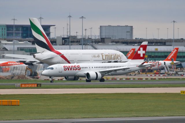 Airbus A220-300 (HB-JCO) - Airbuses everywhere.  SWR394 the early afternoon arrival from Zurich passes an assortment of Easyjets and the Emirates on T1.