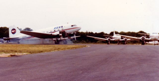 Douglas DC-3 (N33PB) - N33PB smoky start at Hyannis MA-PBA. Martin 404 flightline in the rear.