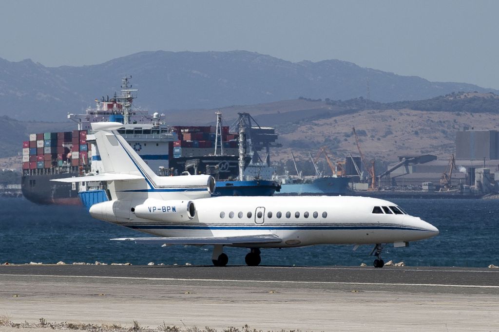 Dassault Falcon 900 (VP-BPW) - In Marina Bay on a boat near the end of the runway - at the west end/threshhold of 09 the runway is built out into the bay (Gibraltar Harbour) - the image is sharp but there is much heat rising off the runway