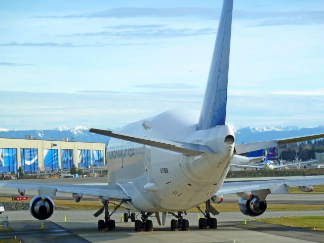 Boeing 747-400 (N718BA) - 1-28-2011 Dreamlifter 747-407 LCF, N718BA in preparation for a show parked at back of Mukilteos Future of Flight Aviation Center just west of Paine Field, Everett, Washington  ||||  Note the photo also shows the blue hangar doors of the Boeing Company Assembly plant in Everett, Washington in the background on the opposite side of the Paine Field main runway |||| Photo by Bruce McKinnon