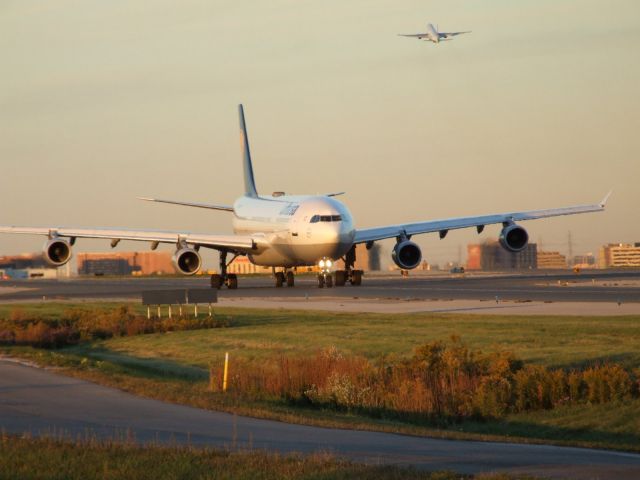 Airbus A340-300 (D-AIGH) - DLH A340 taxi to 06L at CYYZ while a JetAirways A330 takes off behind it.