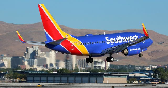 Boeing 737-700 (N7874B) - Caught here landing on Reno Tahoe Internationals runway 34R shortly after 8 AM this morning.  Stands out quite nicely against the Reno city skyline and Peavine Mountain in the background.