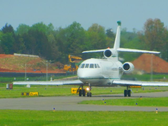 Dassault Falcon 900 (N711FJ) - A Falcon 900 Taxiing To The Runway While Construction Goes On At The Distance At The Manassas Airshow 2018