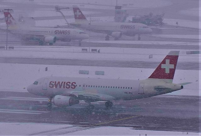 Airbus A319 (HB-IPU) - Swiss taking off in the snow @ Zurich. Sorry for lack of clarity