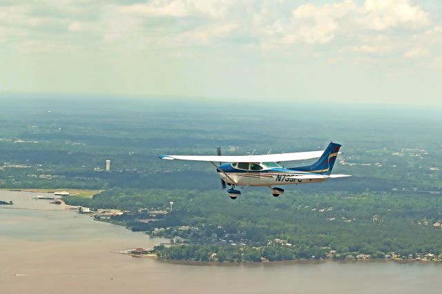 Cessna Skylane (N735FC) - Photographer Alana Donovan captured this image of 735FC for Wesley Flyers Inc. She shot from the right seat of Wesleys 182RG N6245S while both planes flew south over the Ross Barnett Reservoir just east of our home base at KMBO in Madison MS. The Magnolia (MHZ) VOR on the field at MBO is visible at the far right of the photo straight out from 5FCs tail.