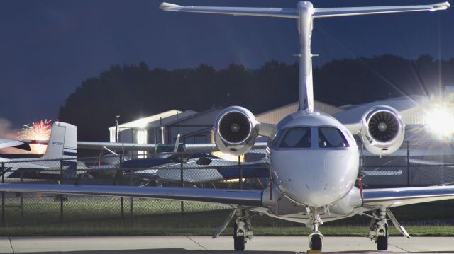 Embraer Phenom 300 (N300GV) - I know the glare is bad but I thought it was a cool shot. br /br /N300GV with fireworks off the right wing. br /br /7/1/23