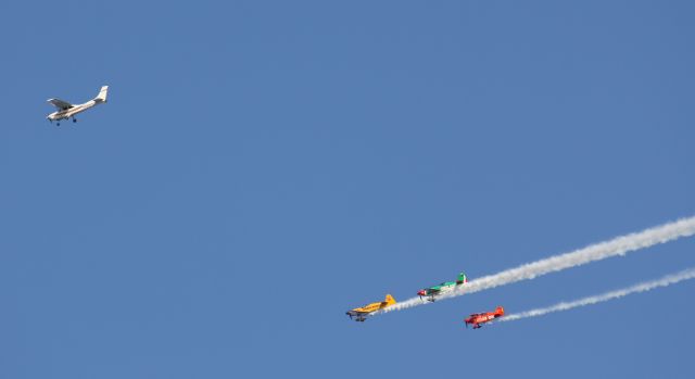 — — - Cessna flying in formation with three acrobatic planes over Canadian National Exhibition,Toronto,Canada.