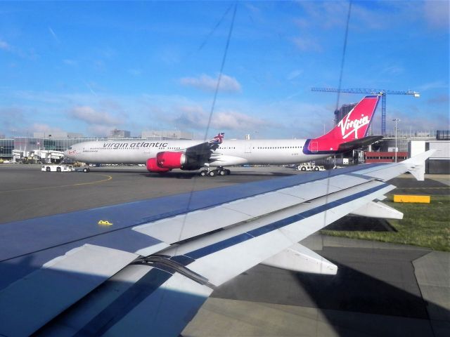 Airbus A340-600 (G-VFIT) - Ugh those window scratches!  G-VFIT, Airbus A340-642 being towed to remote parking between JFK flights.  From seat 20F of EI-DEG, Airbus A320-214 operating EI155 to DUB.