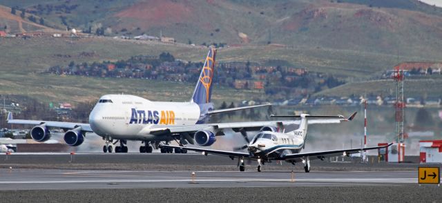 Pilatus PC-12 (N404TC) - An Atlas B744 is on its "D" roll along 16R as a Pilatus PC-12 rolls out after landing on 16L.