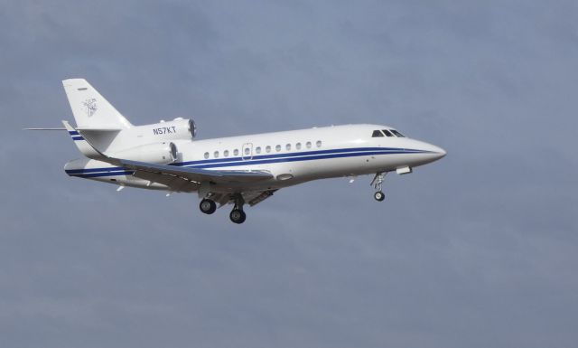 Dassault Falcon 900 (N57KT) - On final is this 2002 Dassault Falcon 900EX in the Winter of 2019. The image on the tail is a workman performing some work at the top of a utility pole with his tools.