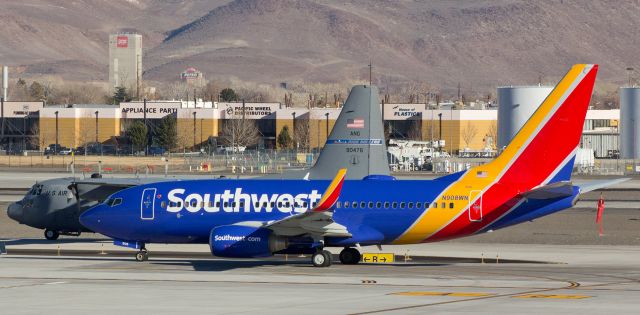 Boeing 737-700 (N908WN) - A rather unique "parallel taxi" shot shows Southwests N908WN taxiing north on Alpha as a Nevada Air Guard "High Rollers" Hercules (79-0476) taxies north on Bravo.  The passengers on the right had a super closeup view of the Herc as the two aircraft moved side-by-side all the way to the ends of the taxiways where the Southwest flight was then cleared to be the first to move on to RNOs runway 16R for departure. 