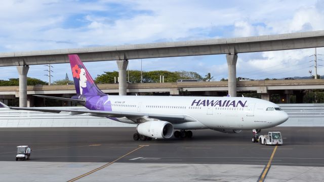 Airbus A330-200 (N374HA) - Airplane being towed at Honolulu International Airport with Nimitz highway and the rail in the background.