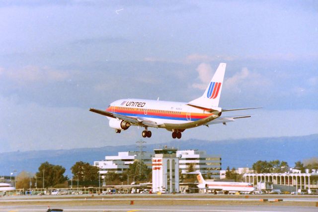 BOEING 737-300 (N306UA) - KSJC - early 1990s from the "utility box" spot - I used to videotape here for hours any day of the week for almost 20 years including with my son from the time he was 3yrs old...only hassled once by a SJPD cop who was not an airport regular - only on lite duty for awhile - once I named dropped a few of the regular SJIA airport cops he left......