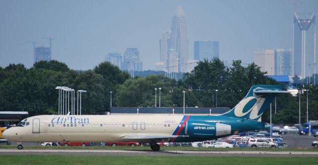 Boeing 717-200 (N950AT) - Taxiing to runway 18C with the Queen City in the background - 6/28/09