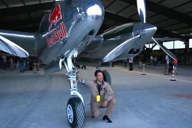 Lockheed P-38 Lightning (N25Y13) - Raimund Riedmann flying bulls next  to the landing gear of Lockheed P-38L Lightning , La Ferté-Alais Airfield (LFFQ) Air Show (Le Temps Des Hélices) in may 2012