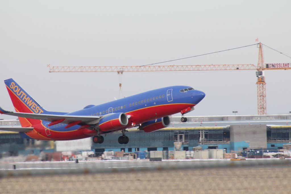 Boeing 737-700 (N938WN) - 030414 SWA rotating from Rwy 19R. The new Eisenhower terminal construction in the background