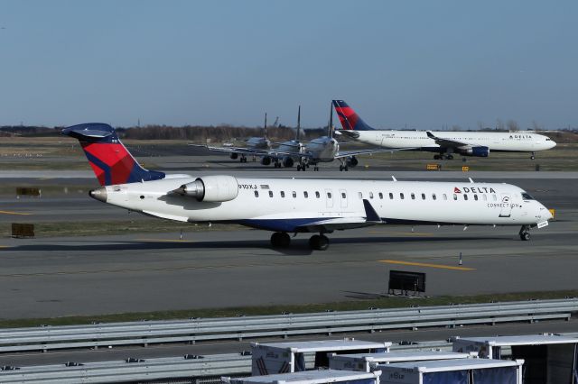 Canadair Regional Jet CRJ-900 (N910XJ) - EDV3310 from Nashville taxies to the gate as the queue for departure on 31L increases in the background.