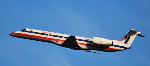 Embraer ERJ-135 (N833AE) - Fresh from the desert, this old Embraer takes to the skies. Miss the old American Eagle livery, so it was a treat to see it, faded decals, cheatline, and all! From the RDU parking deck, 4/14/18.