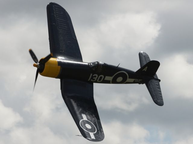 — — - A Vought F4U Corsair races through the sky over Duxford Air Museum, during the Flying Legends 2012 weekend.