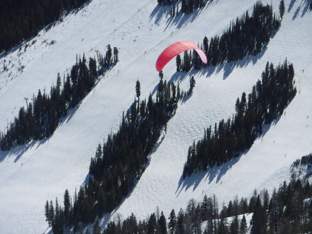 — — - Para glider floating over the Seattle Ridge ski runs of Baldy Ski Hill in Sun Valley, Idaho