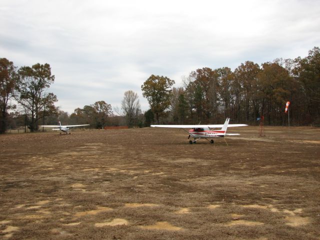 Cessna Commuter (N704RW) - Our 172E taxis to depart to the south as the 150 sits tied down next to the wind sock at our grass airstrip in northern Mississippi.