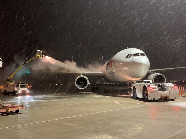 Airbus A300F4-600 (N647FE) - 24 year old Airbus A300F4-605R "Mark" gets his starboard wing sprayed with propylene glycol.  A wet heavy March snow has just begun to fall on FedEx Flight 325.