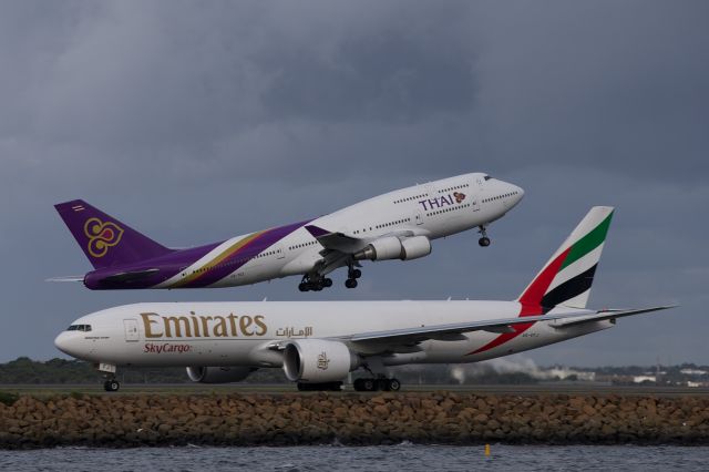 Boeing 777-200 (A6-EFJ) - Thai Airways 747-400 was overflying Emirates SkyCargo 777F in YSSY RWY16R