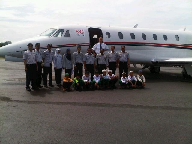 Cessna Citation Sovereign (N570RZ) - Security and Local school kids.  Batulicin, Kalimantan