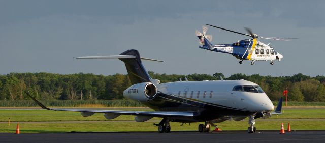 Canadair Challenger 350 (N570FX) - MORRISTOWN, NEW JERSEY, USA-AUGUST 09, 2019: Seen on the ground at Morristown Municipal Airport was this Canadair Challenger 350 twin engine jet. The New Jersey State Police Helicopter seen in the background, registration number N9NJ, was helping provide security for the arrival of Air Force One a short time before.