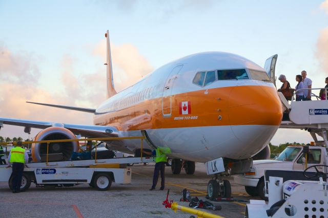 Boeing 737-800 (C-FTLK) - This Boeing 737-800 emplanes passengers and prepares to depart Sint Maarten as SWG 765 - 6 Jan 2013