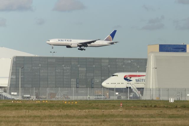 Boeing 777-200 — - The new engine run up enclosure at London Heathrow. A British Airways B747-400 is parked in the enclosure, while a United B777-200ER appraoches runway 027R in the background.