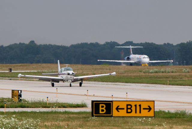 Beechcraft Bonanza (36) (N8486N) - A Beech Bonanza taxies to the ramp at KTOL as AAY5801 (Allegiant MD-83, N876GA) departs RWY25 en route to Clearwater Intl (KPIE) on 23 Jul 2018.
