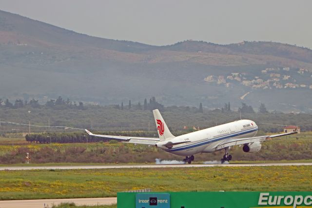 Airbus A330-300 (B-5919) - Air China's 330 burning rubber and creates wingtip vortexes while landing under rain in Athens.